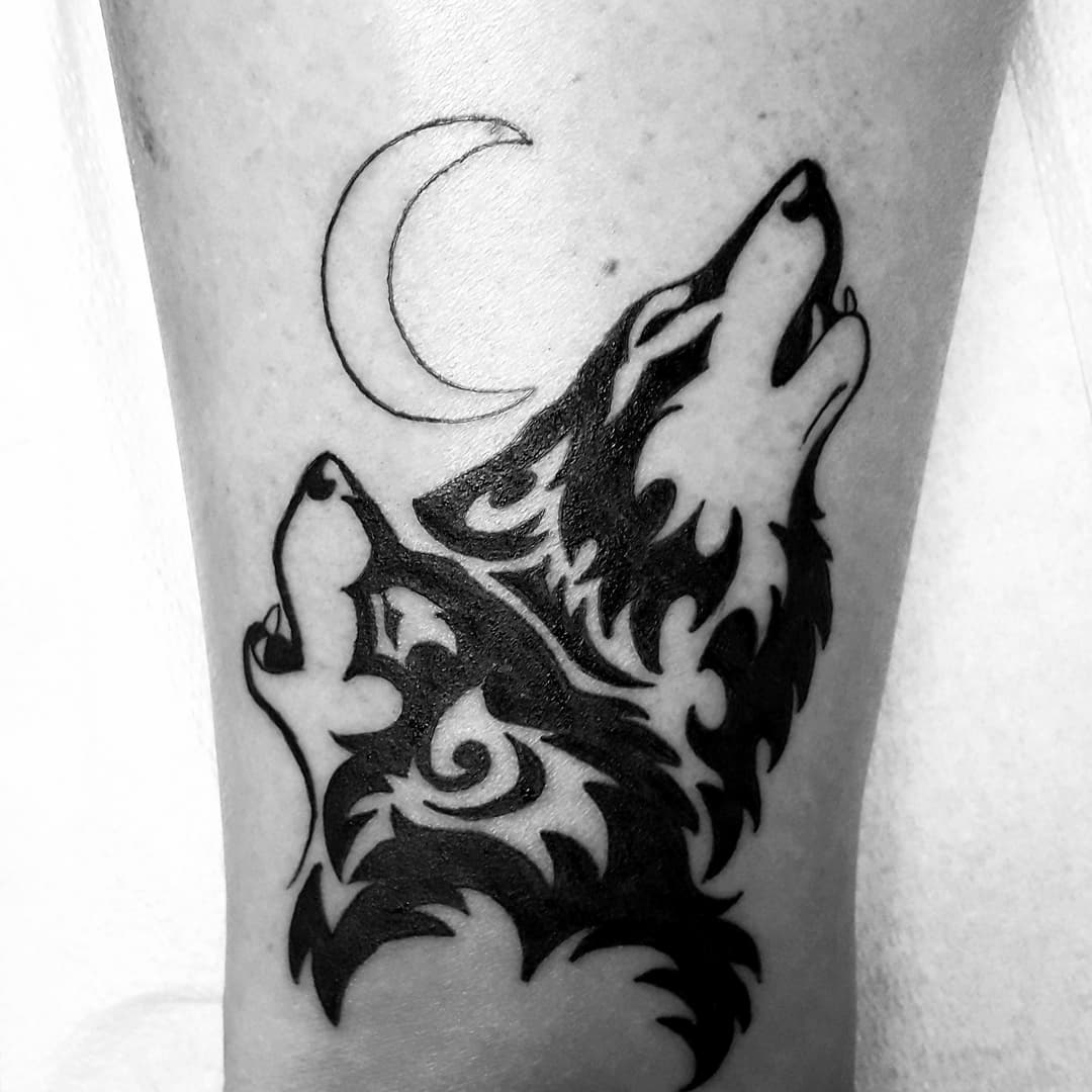 Tribal wolf tattoos under the moon